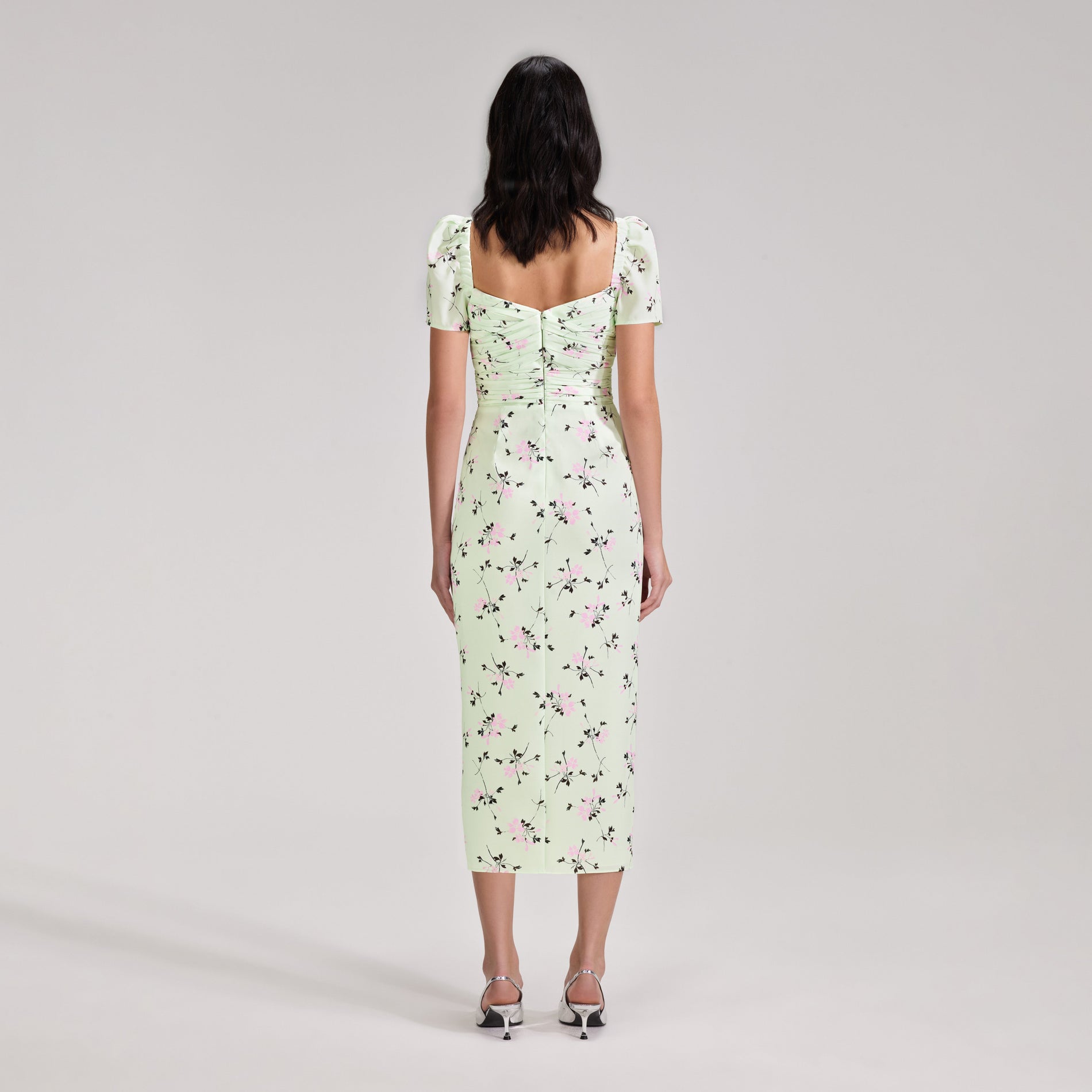 A woman wearing the Green Floral Print Iris Midi Dress