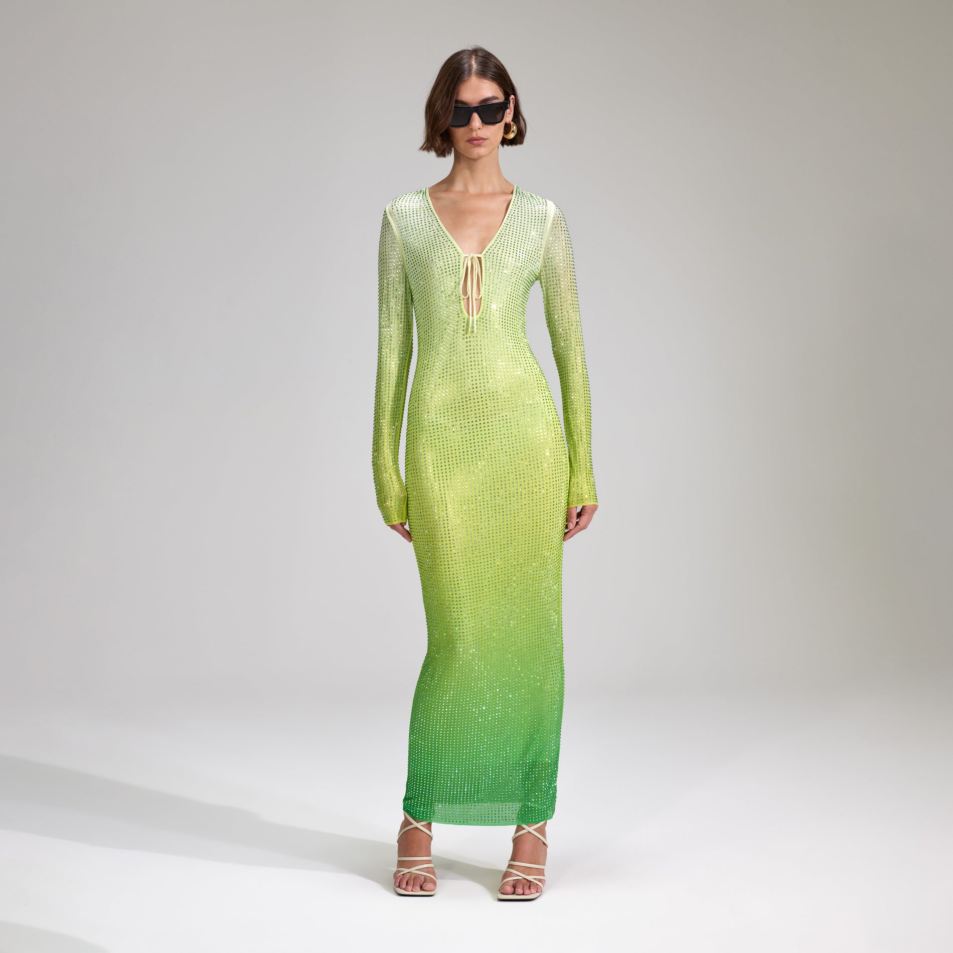 A woman wearing the Green Rhinestone Mesh Keyhole Maxi Dress