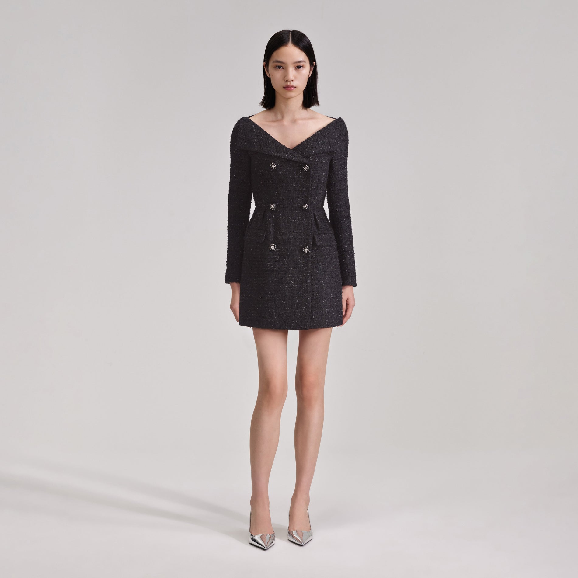 A woman wearing the Black Off Shoulder Boucle Mini Dress