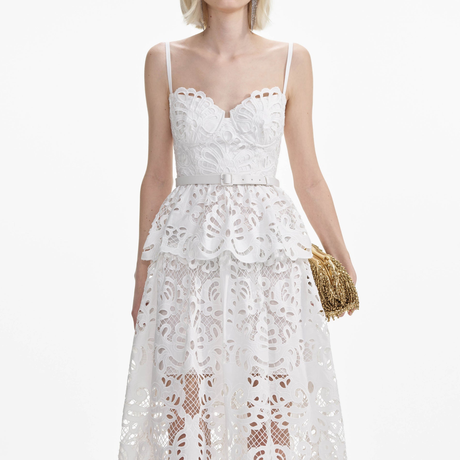 A close up of a woman wearing the White Cotton Lace Tiered Midi Dress