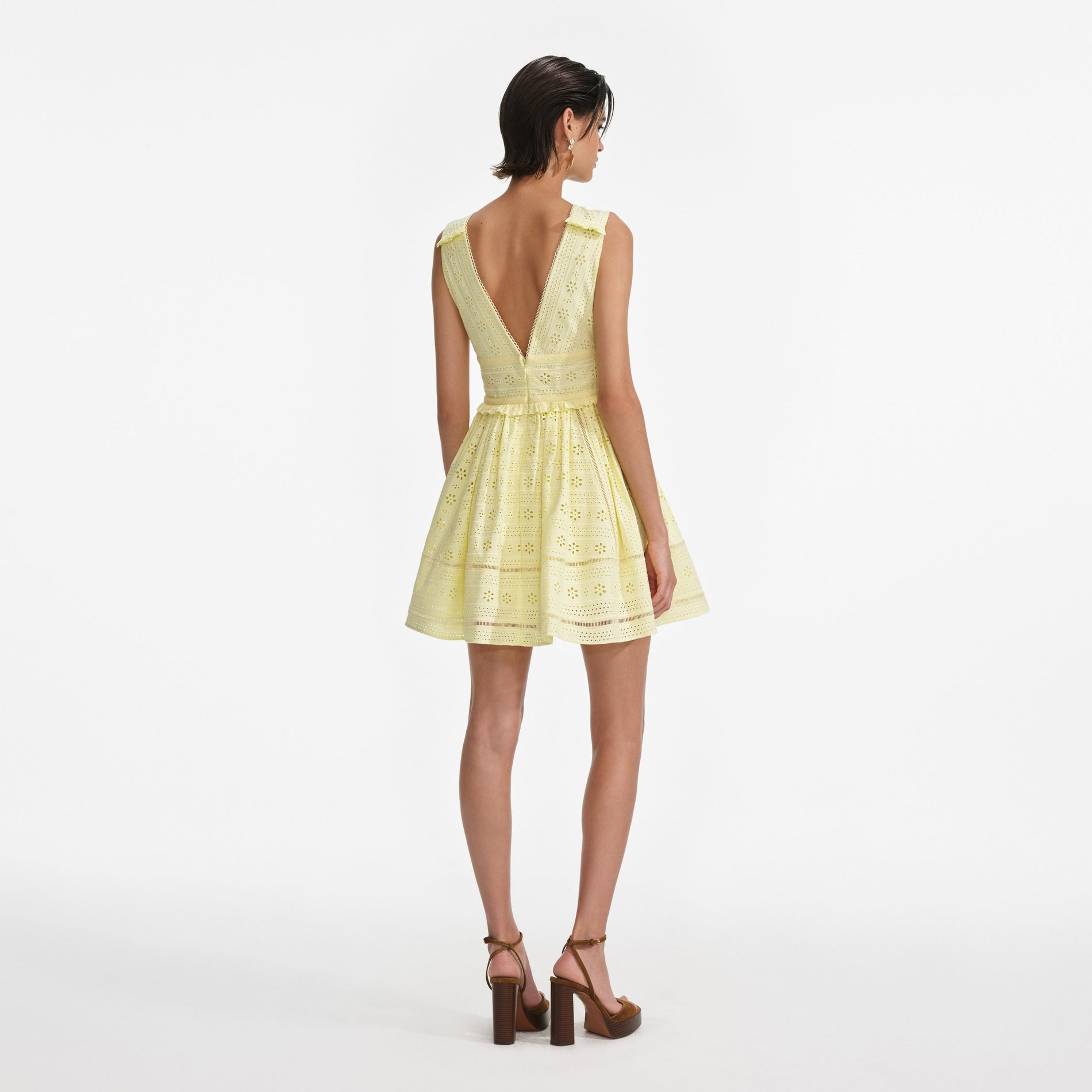 Back view of a woman wearing the Yellow Cotton Broderie Mini Dress