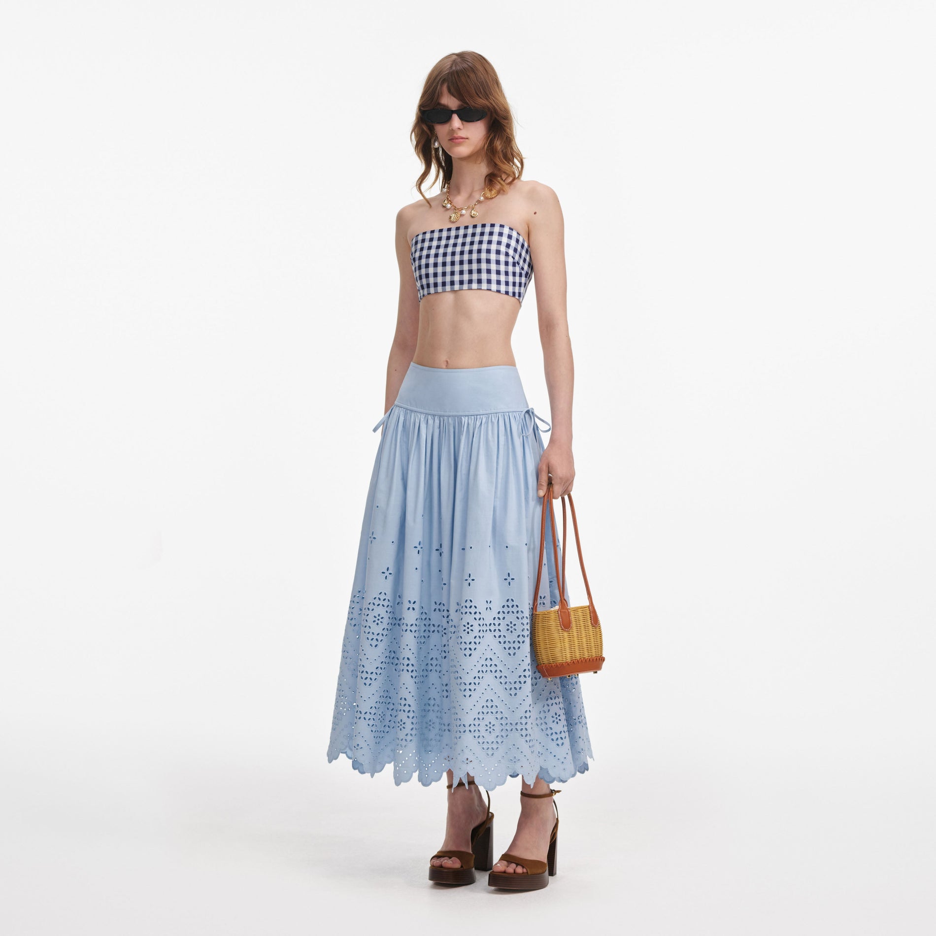 Side view of a woman wearing the Blue Cotton Broderie Midi Skirt