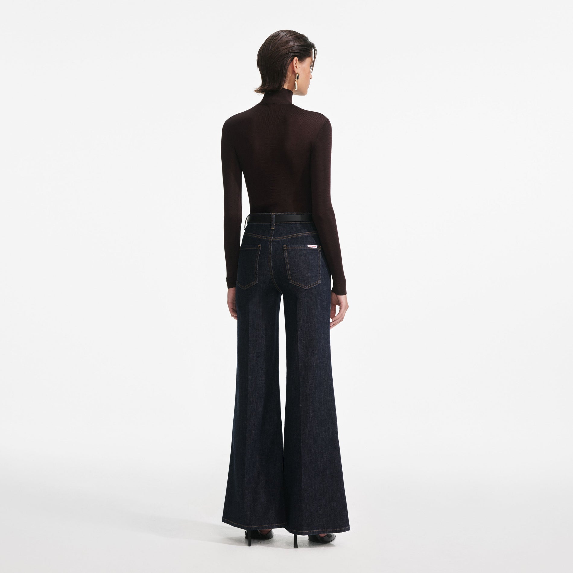 Back view of a woman wearing the Indigo Flared Jeans