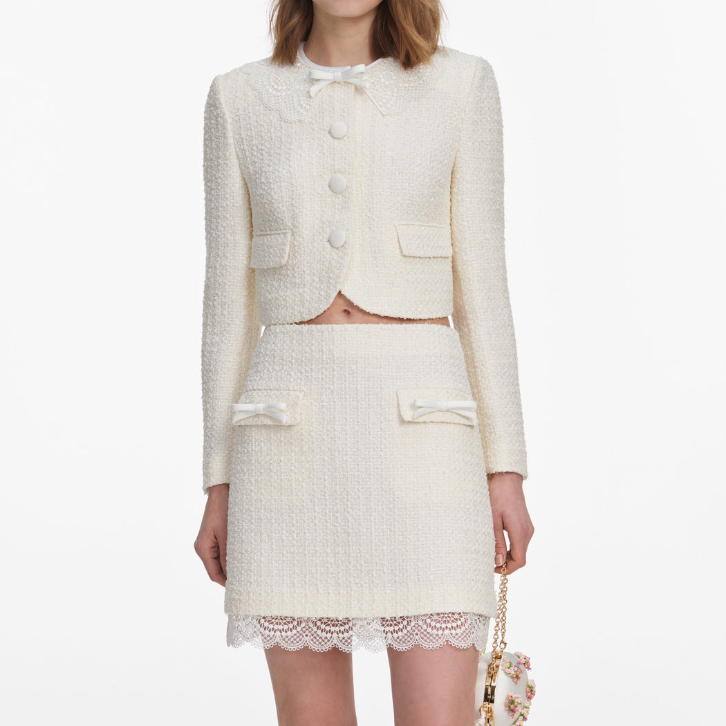 A close up of a woman wearing the Cream Boucle Lace Mini Skirt