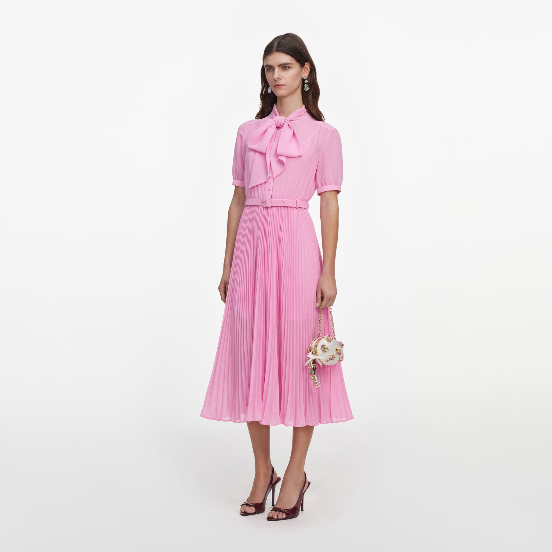 Side view of a woman wearing the Pink Georgette Tie Neck Midi Dress