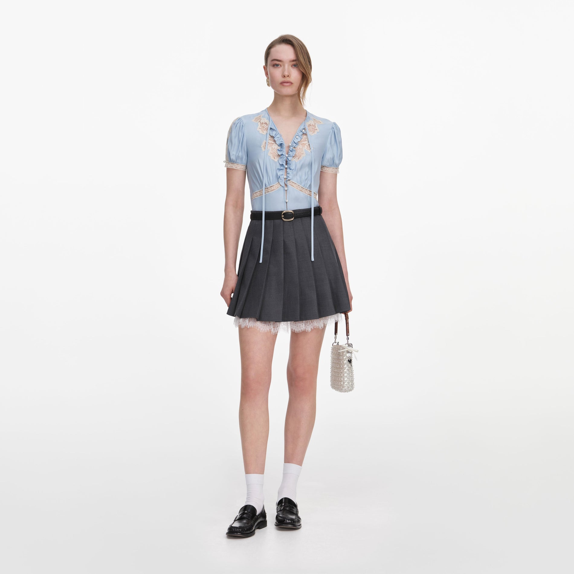 Front view of a woman wearing the Grey Pleated Mini Skirt