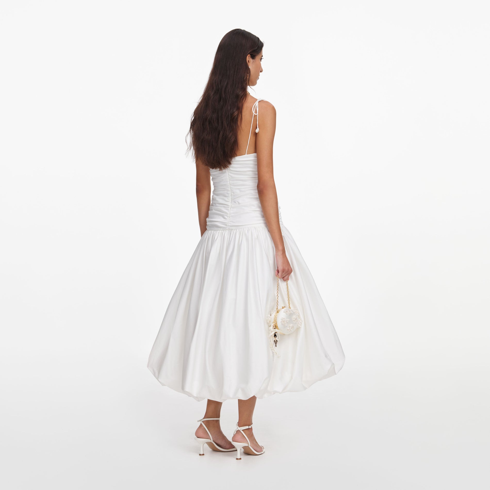 Back view of a woman wearing the White Cotton Gathered Midi Dress