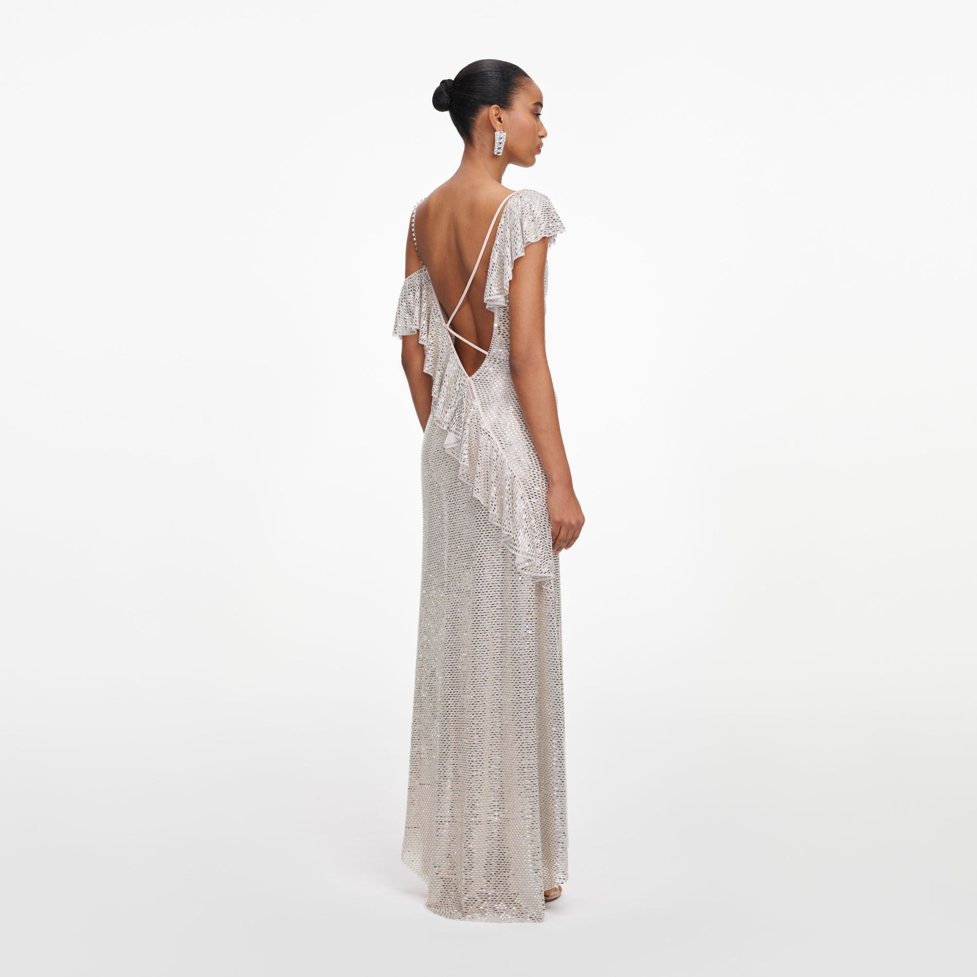 Back view of a woman wearing the Champagne Rhinestone Ruffle Draped Maxi Dress