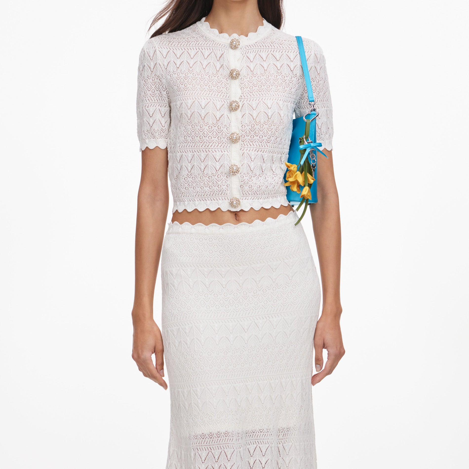 A close up of a woman wearing the White Pointelle Knit Midi Skirt