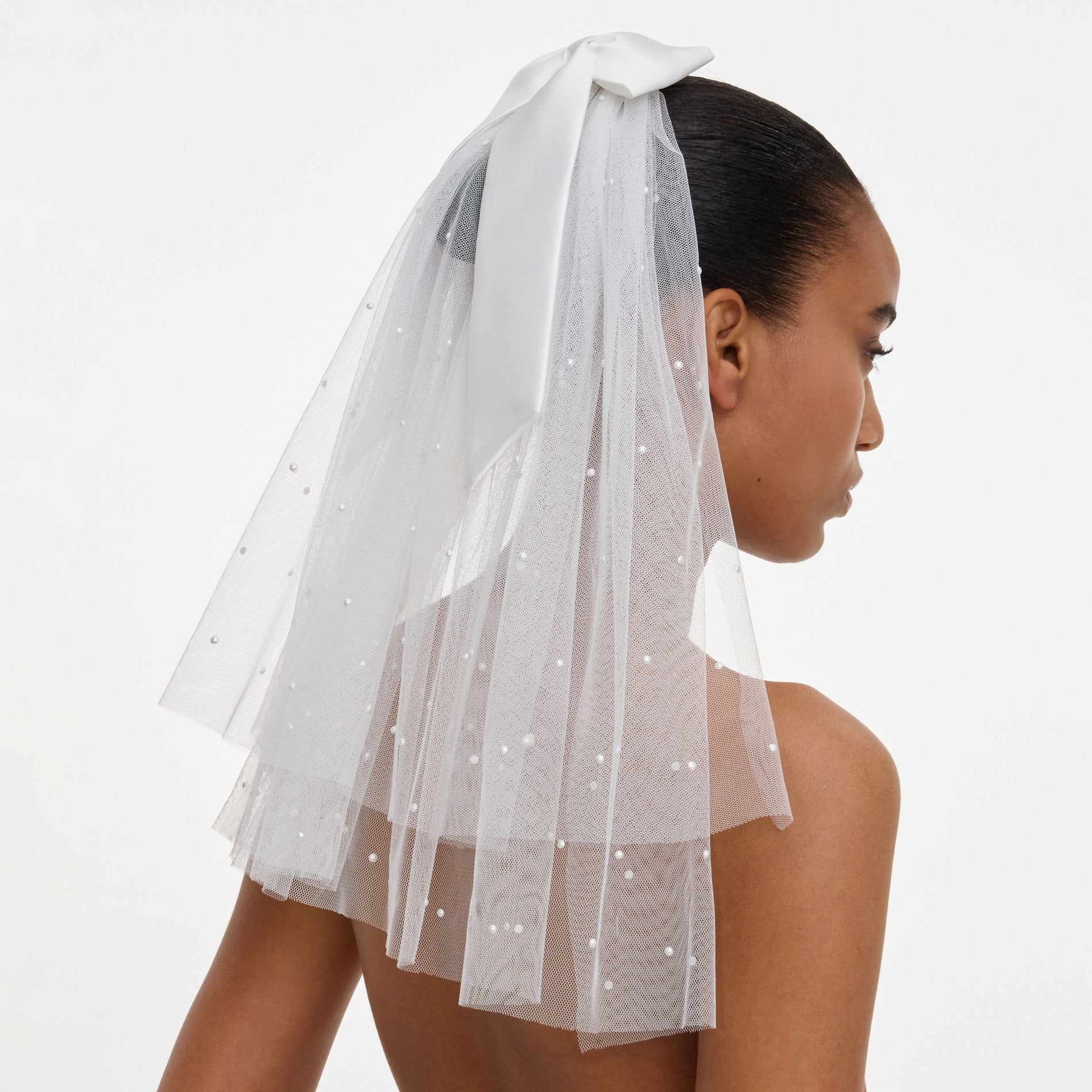 A close up of a woman wearing the Satin Bow Embellished Veil