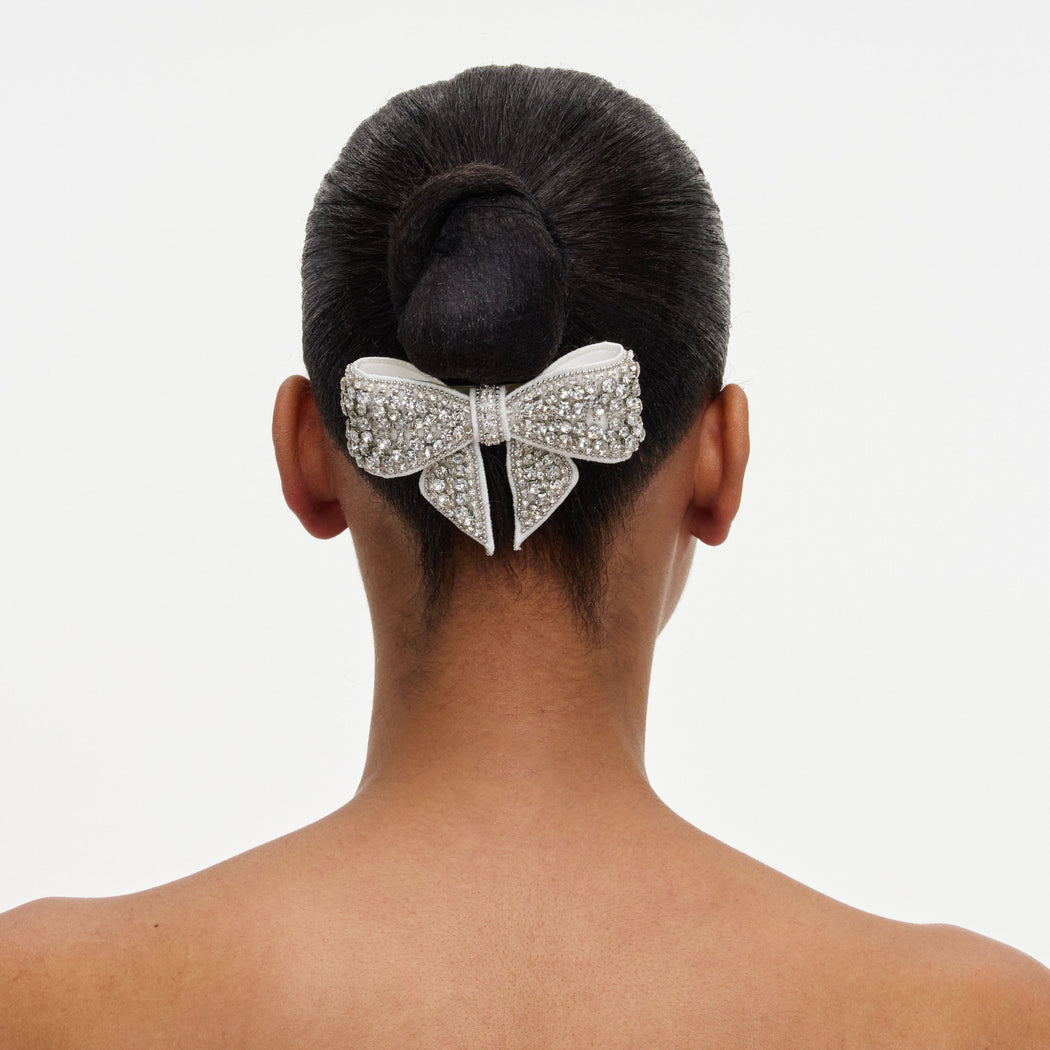 A close up of a woman wearing the Crystal Embellished Bow Hairclip