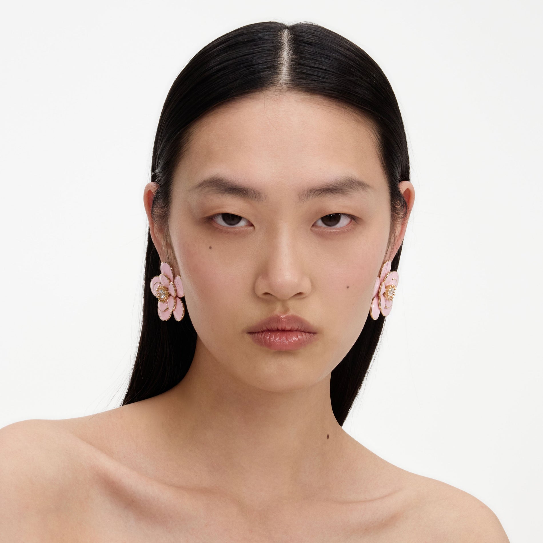 A close up of a woman wearing the Pink Enamel Flower Earrings