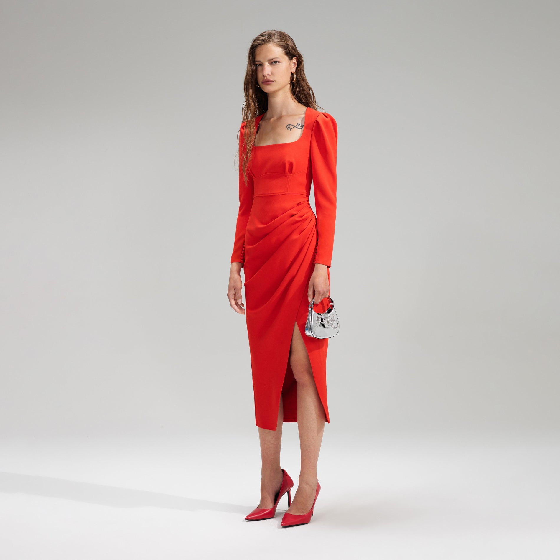 A woman wearing the Red Crepe Ruched Midi Dress