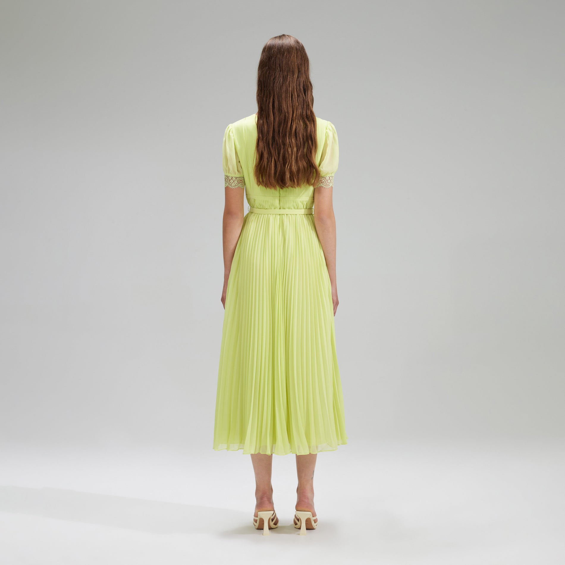 A woman wearing the Lime Chiffon Midi Dress Lace Detail