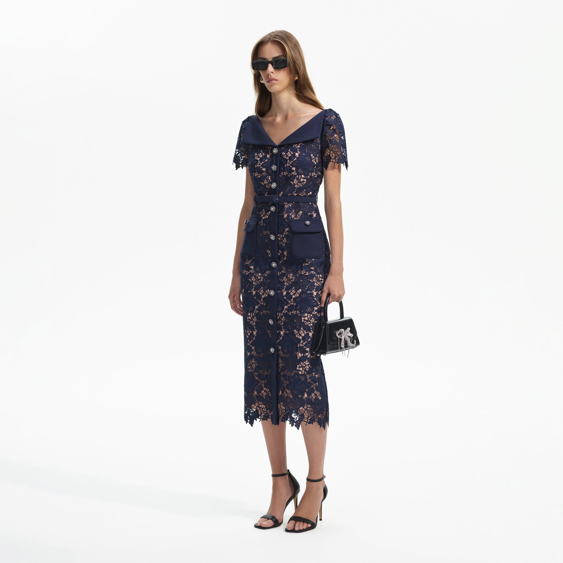 Side view of a woman wearing the Navy Lace Open Neck Midi Dress