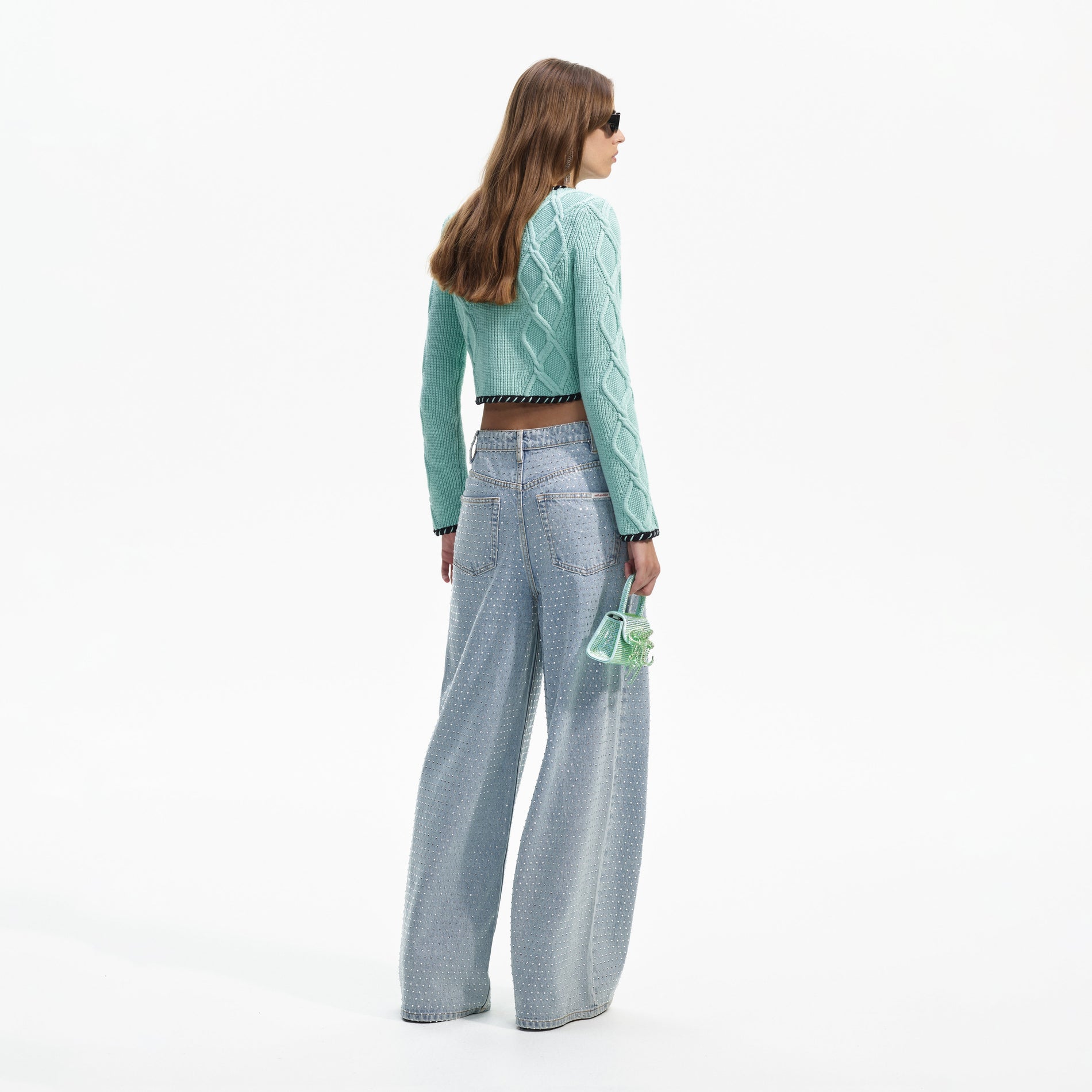 Back view of a woman wearing the Mint Cable Knit Cropped Cardigan