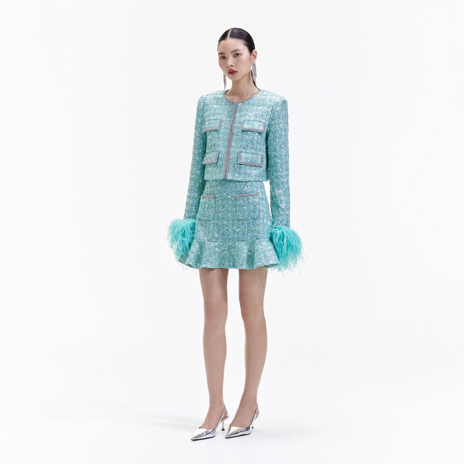Side view of a woman wearing the Blue Boucle Feather Jacket
