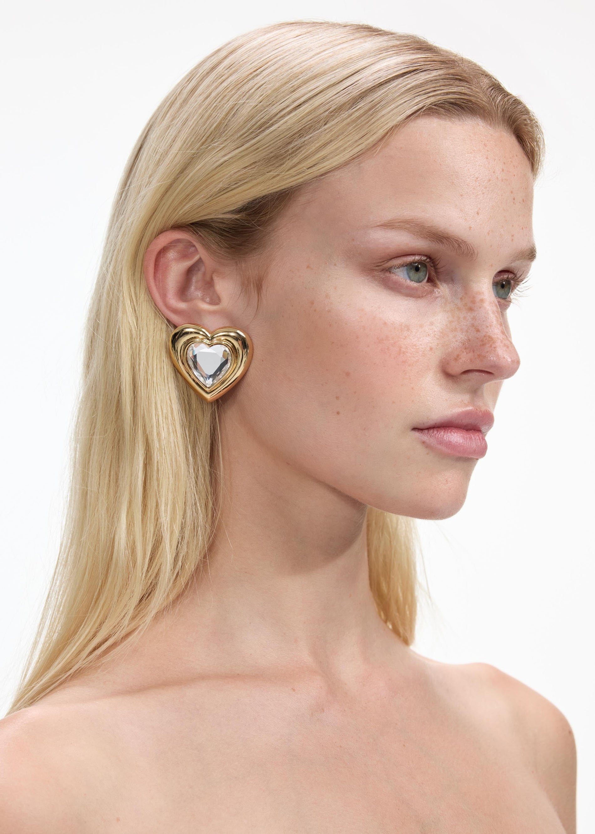 Back view of a woman wearing the Gold Crystal Heart Earrings