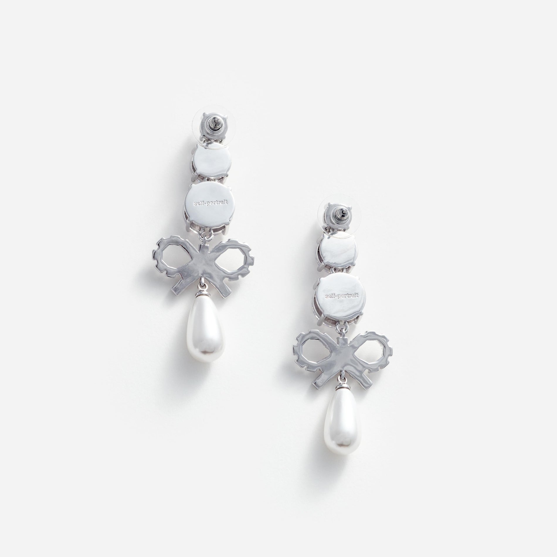 Side view of a woman wearing the Crystal Bow Pearl Earrings