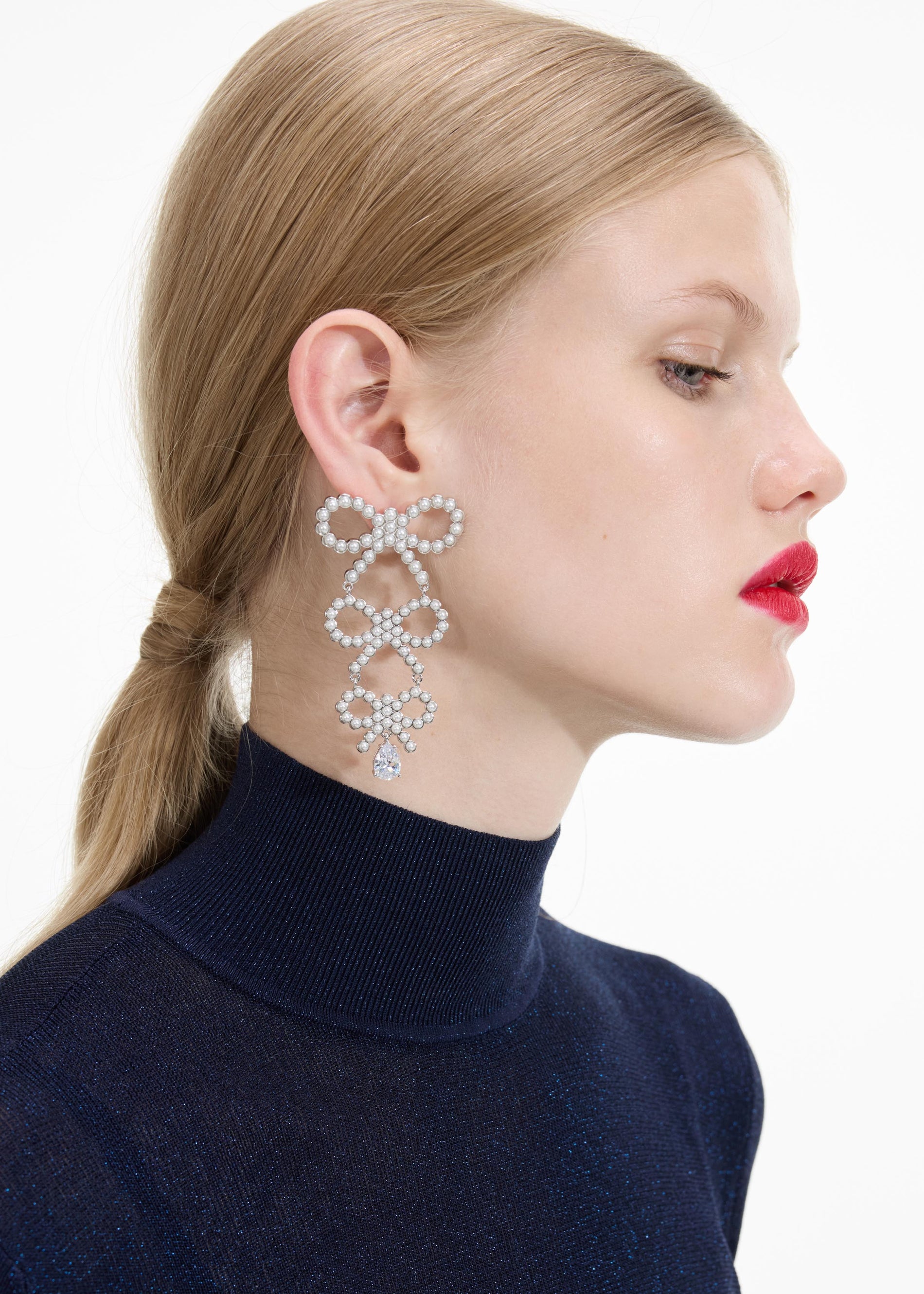 Back view of a woman wearing the Tiered Pearl Bow Earrings