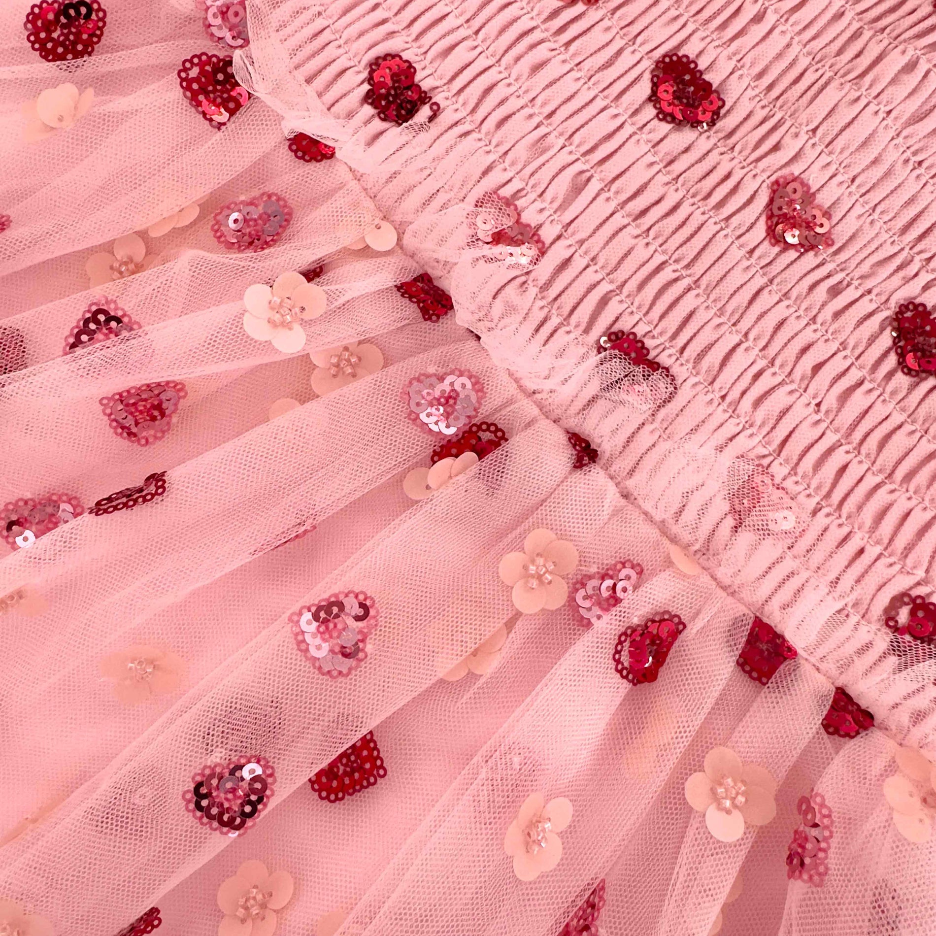 Back view of a woman wearing the Pink Mesh Heart Sequin Dress