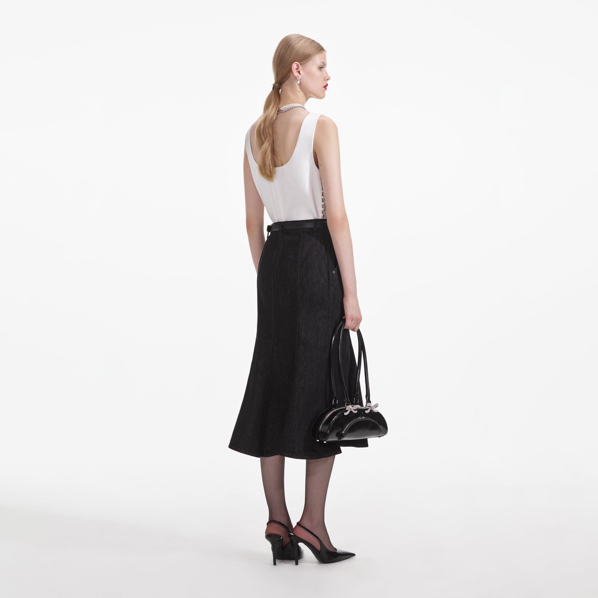 Back view of a woman wearing the Black Flared Denim Midi Skirt