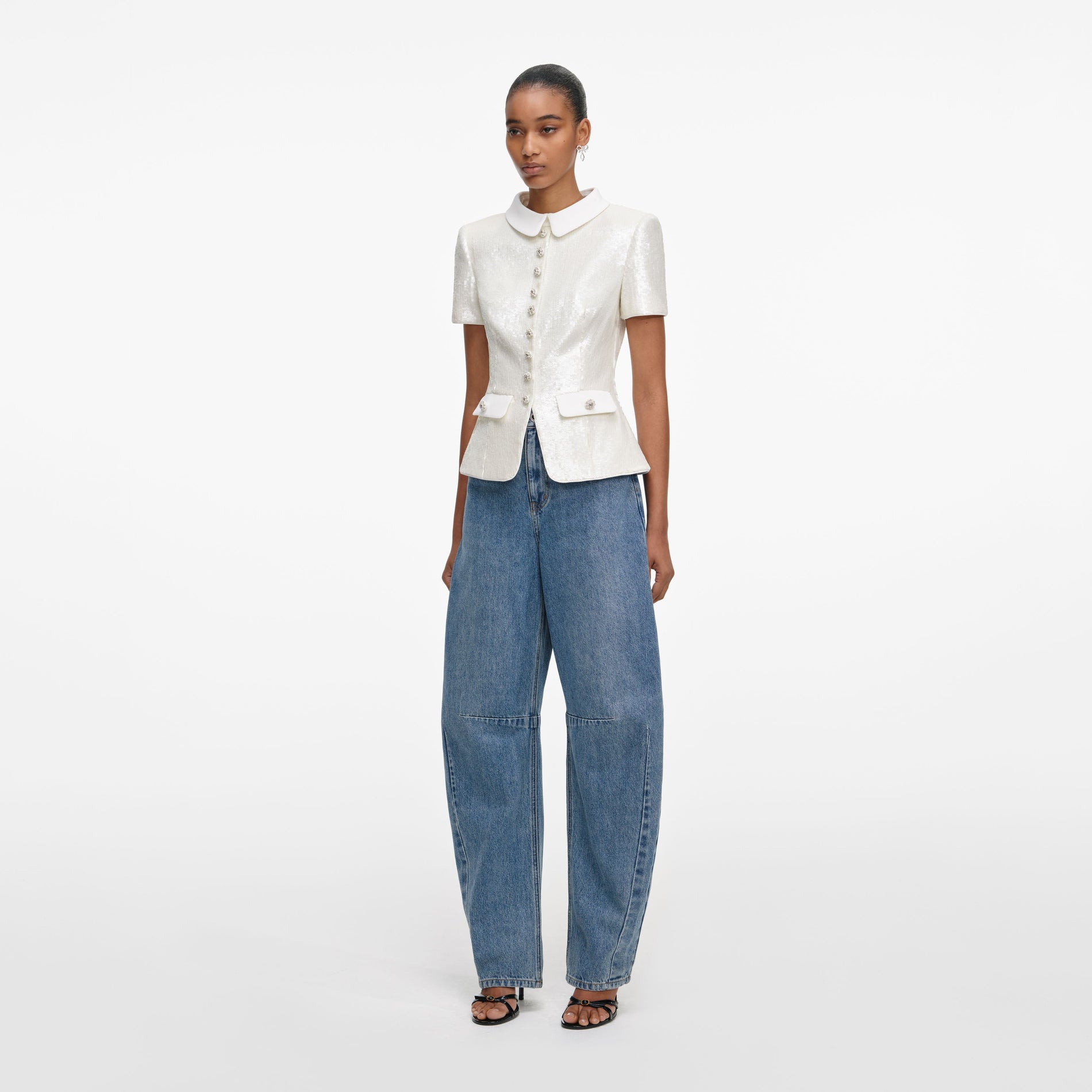 Side view of a woman wearing the White Sequin Tailored Top