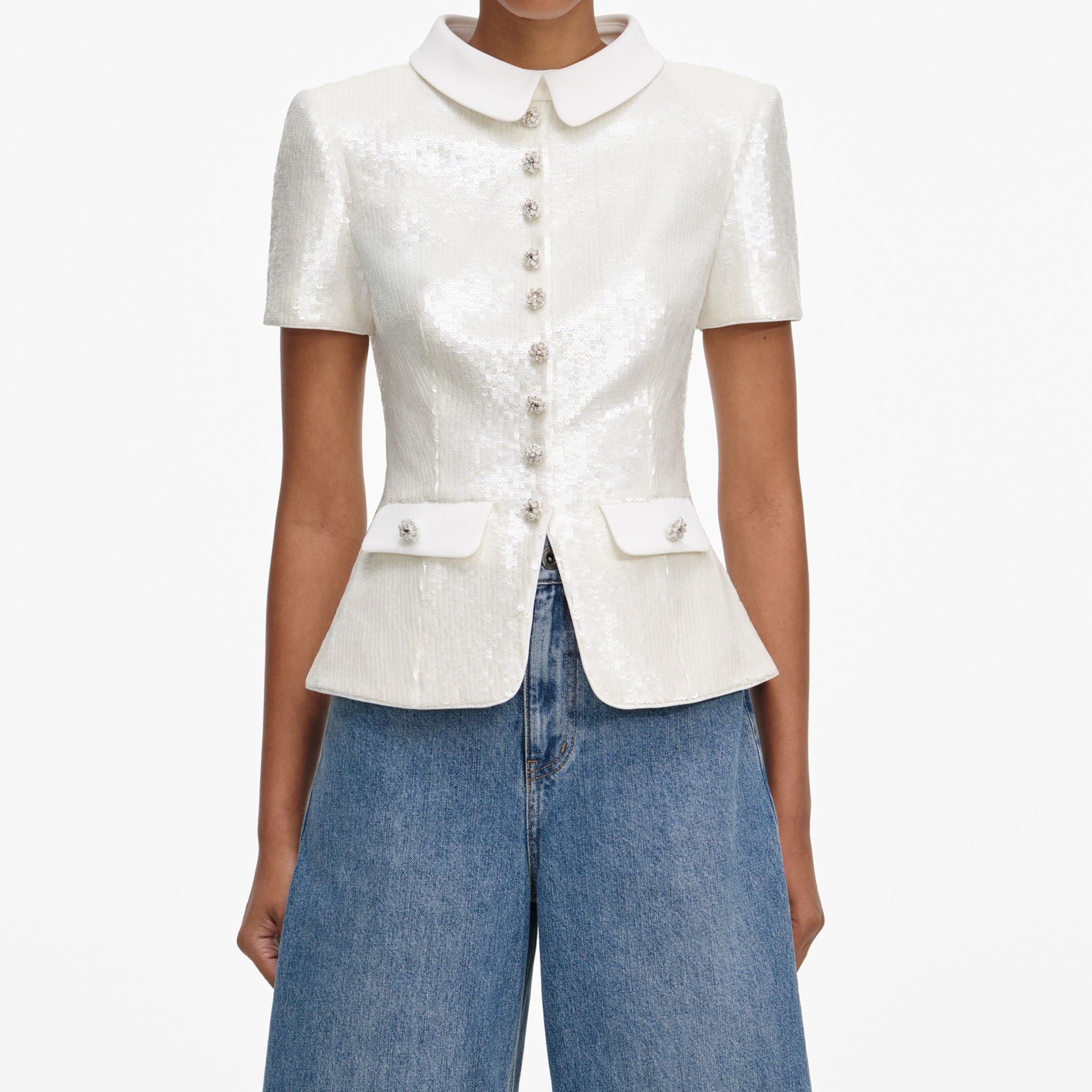 A close up of a woman wearing the White Sequin Tailored Top