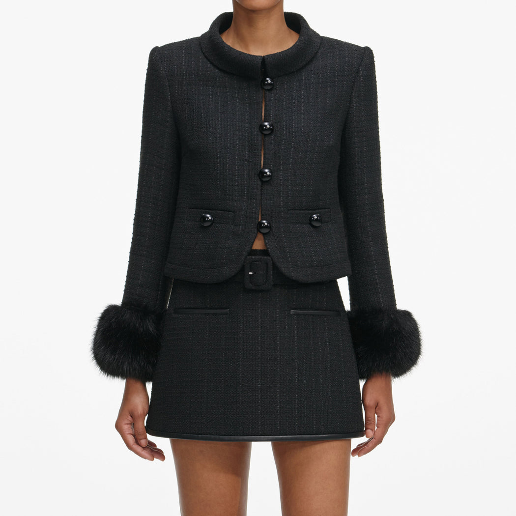 A close up of a woman wearing the Black Boucle Faux Fur Cuff Jacket