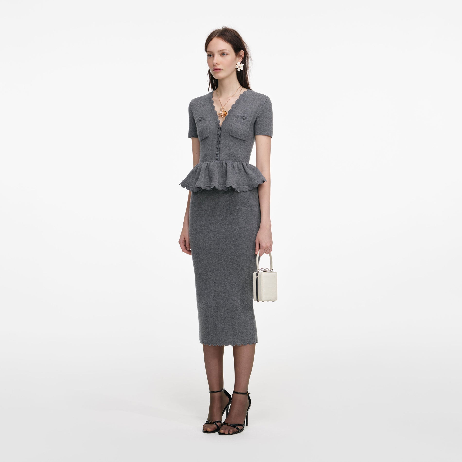 Side view of a woman wearing the Grey Peplum Knit Midi Dress