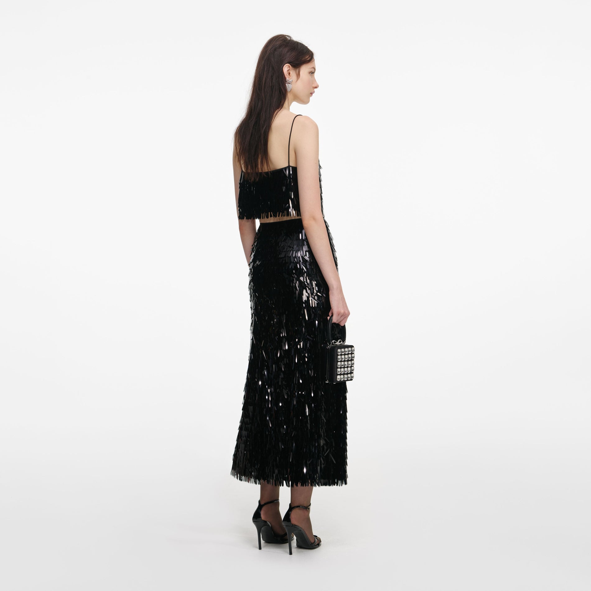 Back view of a woman wearing the Black Sequin Midi Skirt