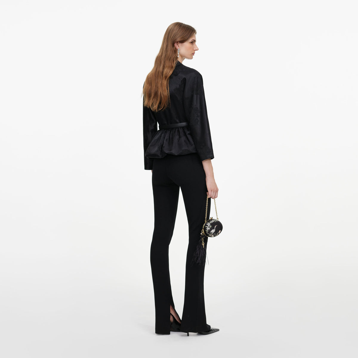 Back view of a woman wearing the Black Jacquard Peplum Top
