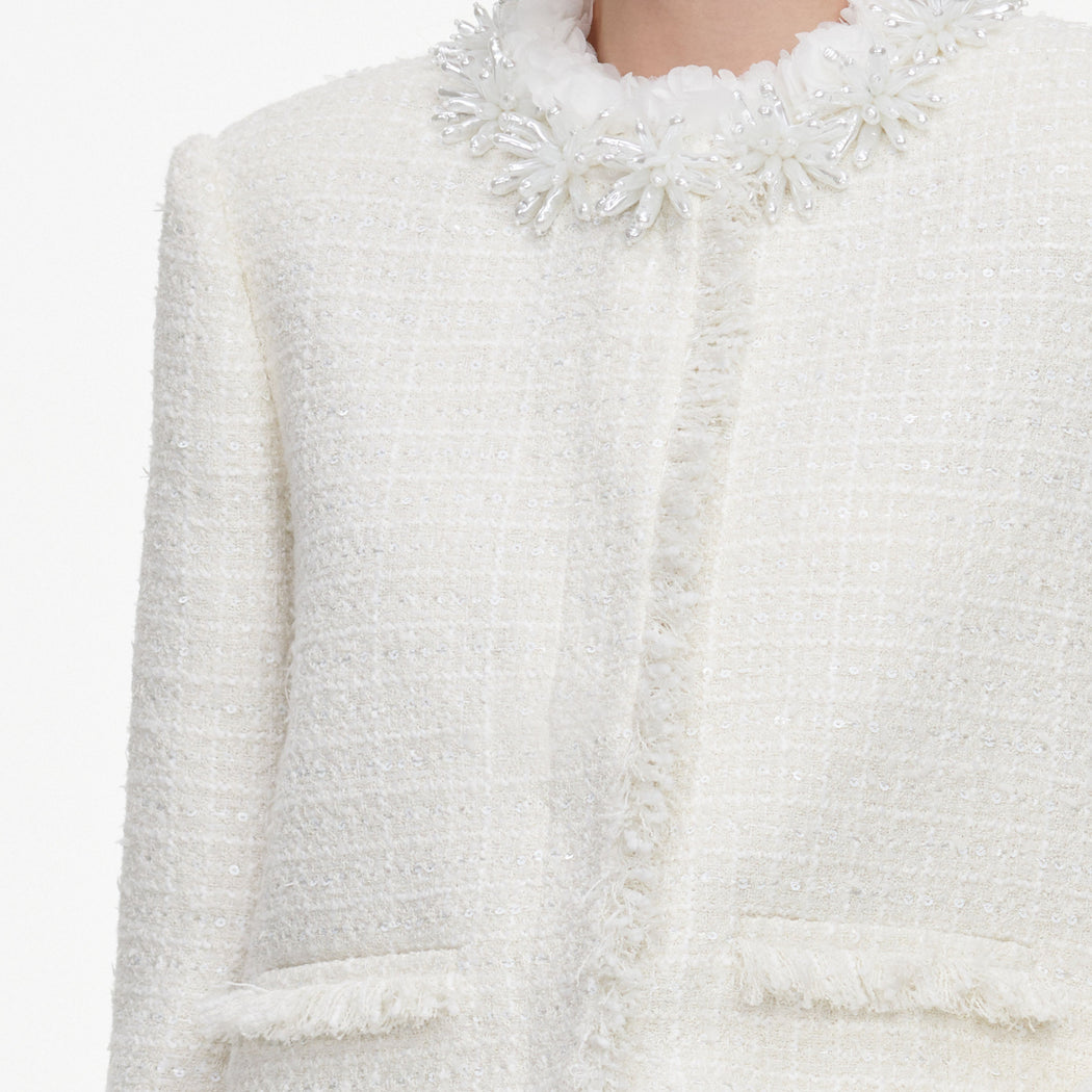 A close up of the fabric for the Cream Sequin Boucle Pearl Trim Jacket
