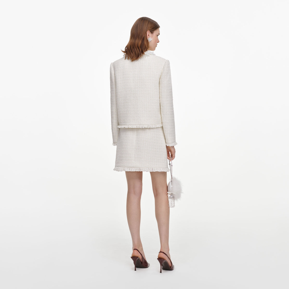 Back view of a woman wearing the Cream Sequin Boucle Mini Skirt