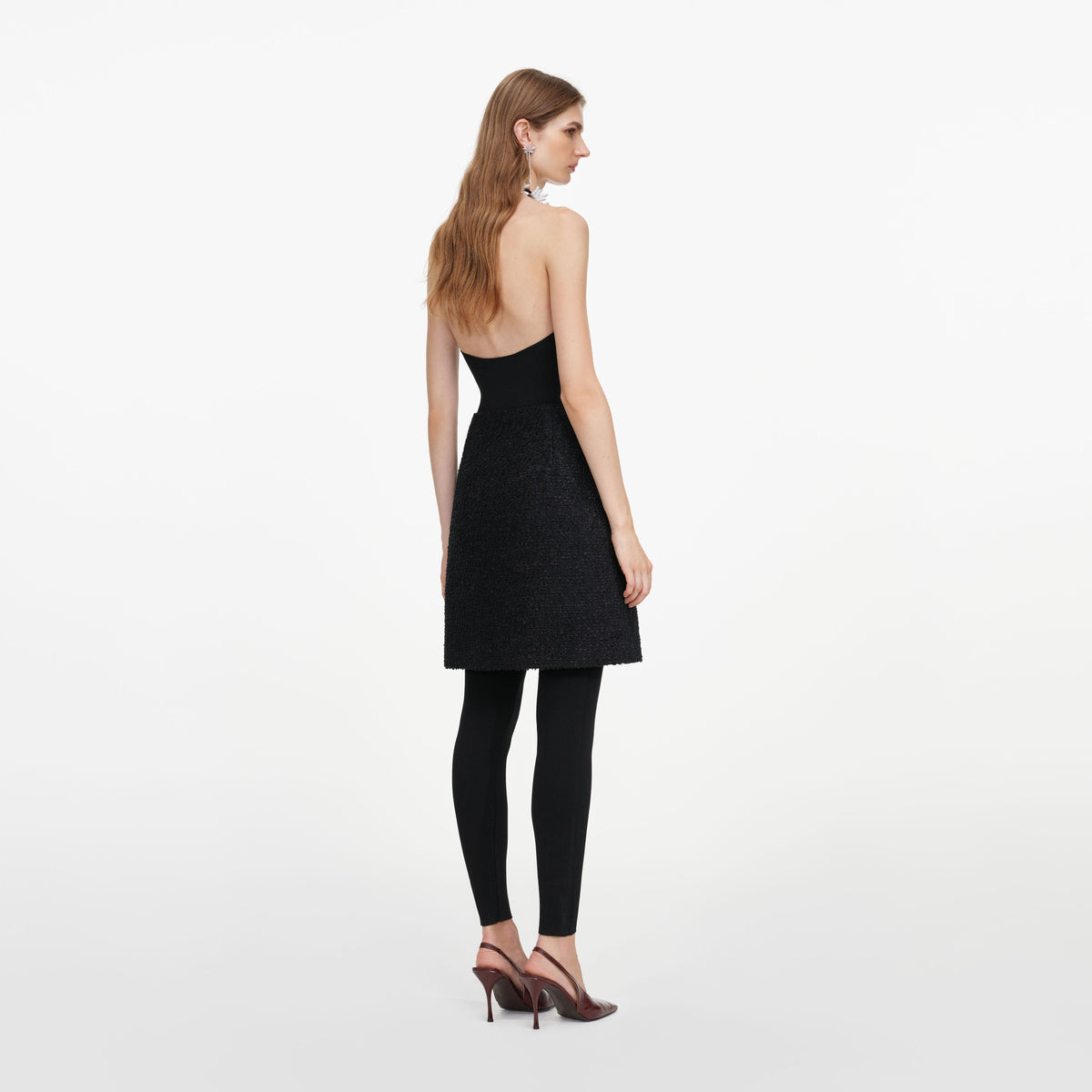 Back view of a woman wearing the Black Boucle Mini Skirt