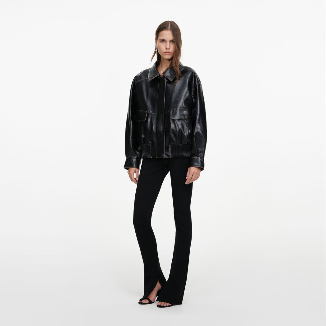 Side view of a woman wearing the Black Oversized Faux Leather Jacket