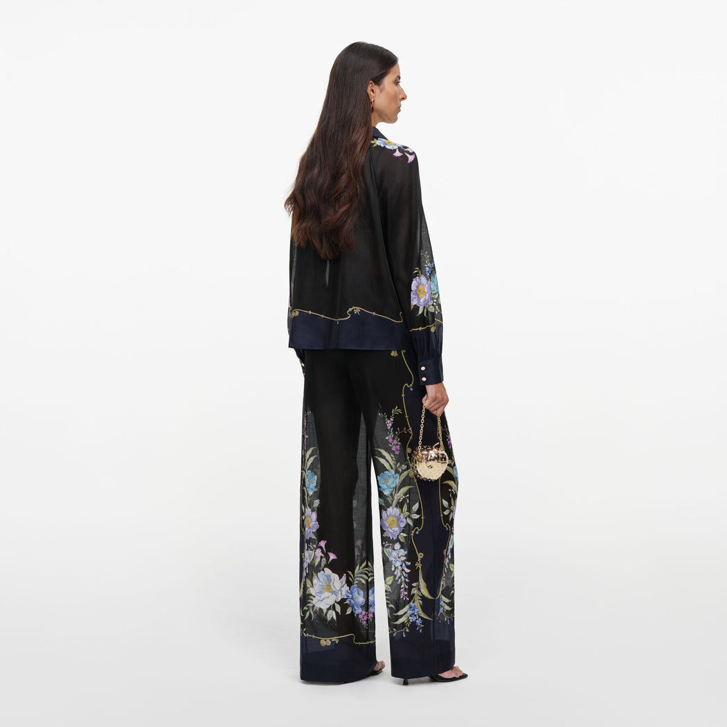 Back view of a woman wearing the Navy Floral Organza Trousers