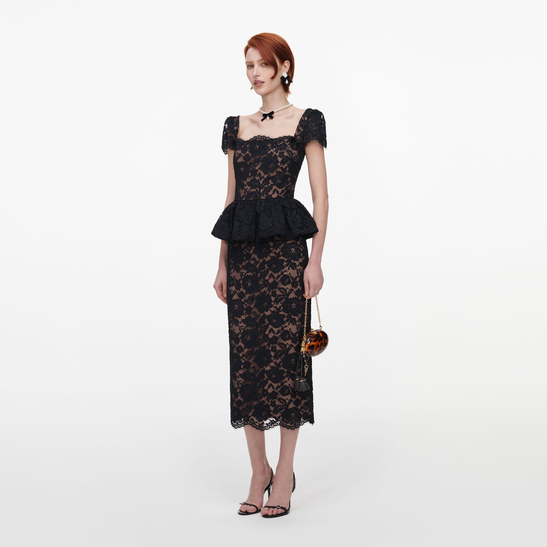 Side view of a woman wearing the Black Fine Lace Peplum Midi Dress