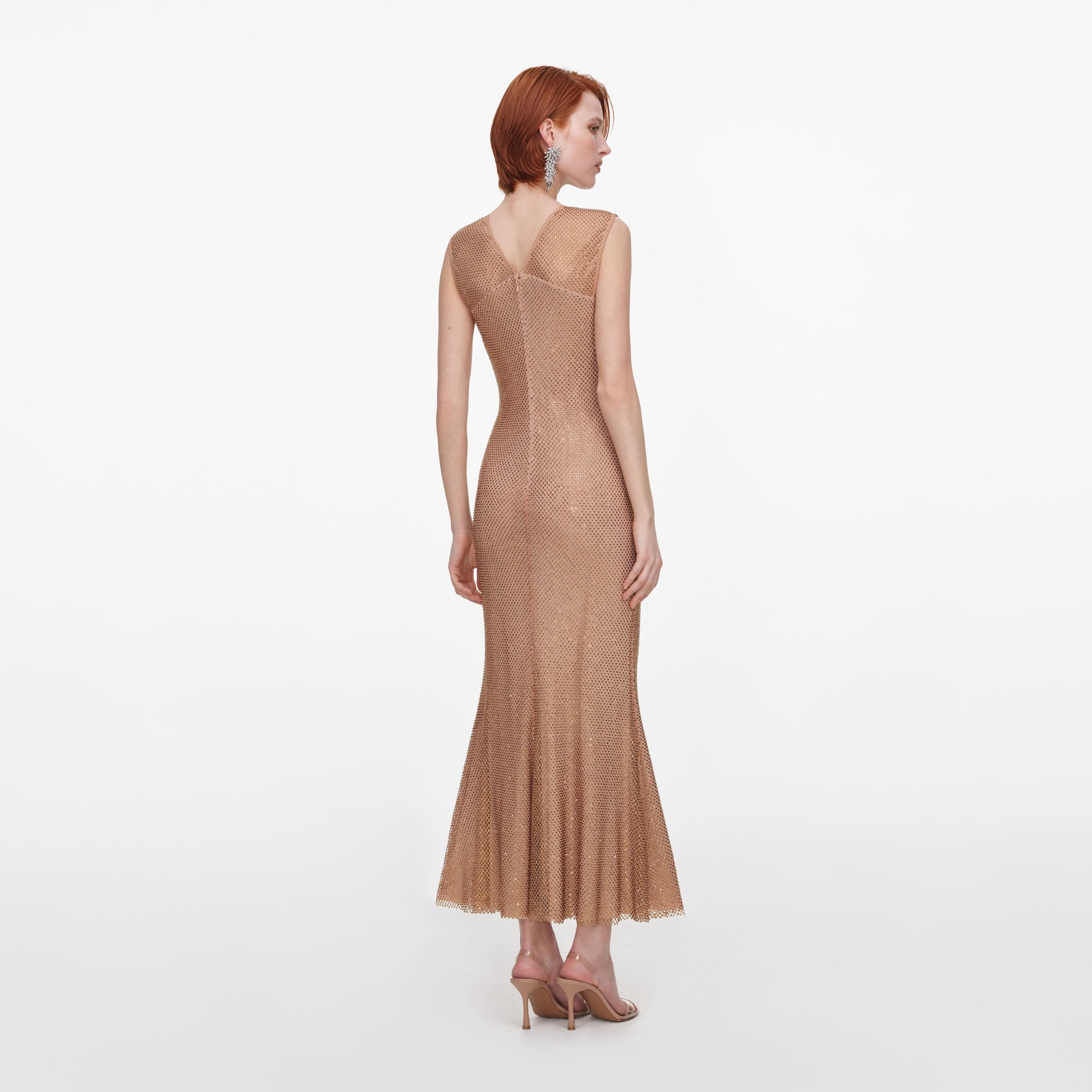 Back view of a woman wearing the Champagne Rhinestone Fishnet Midi Dress