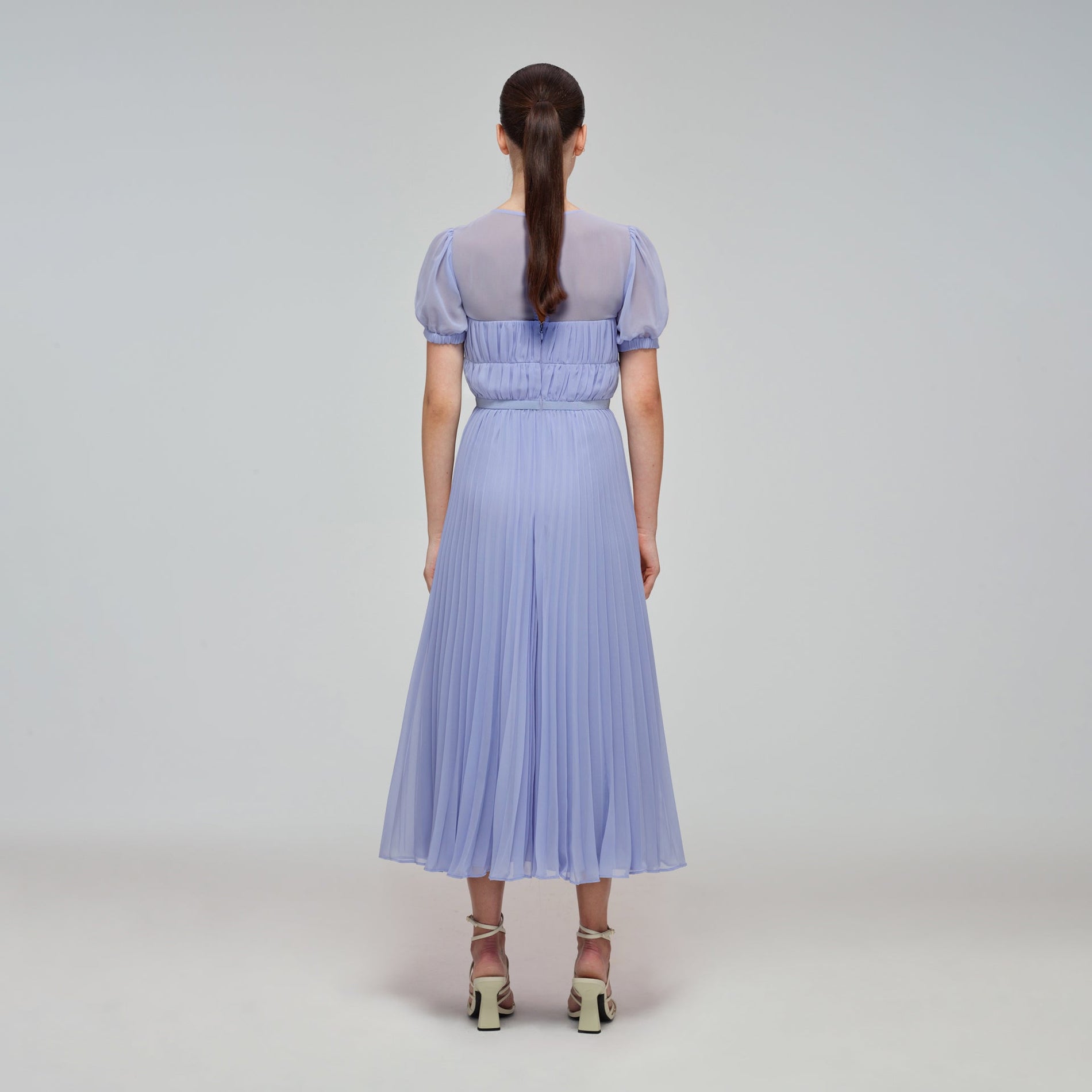 A woman wearing the Lilac Chiffon Pleated Midi Dress