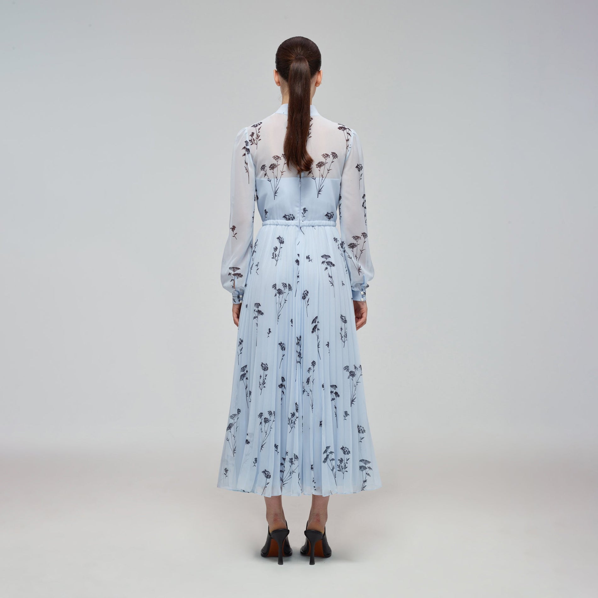 A woman wearing the Blue Floral Silhouette Chiffon Midi Dress