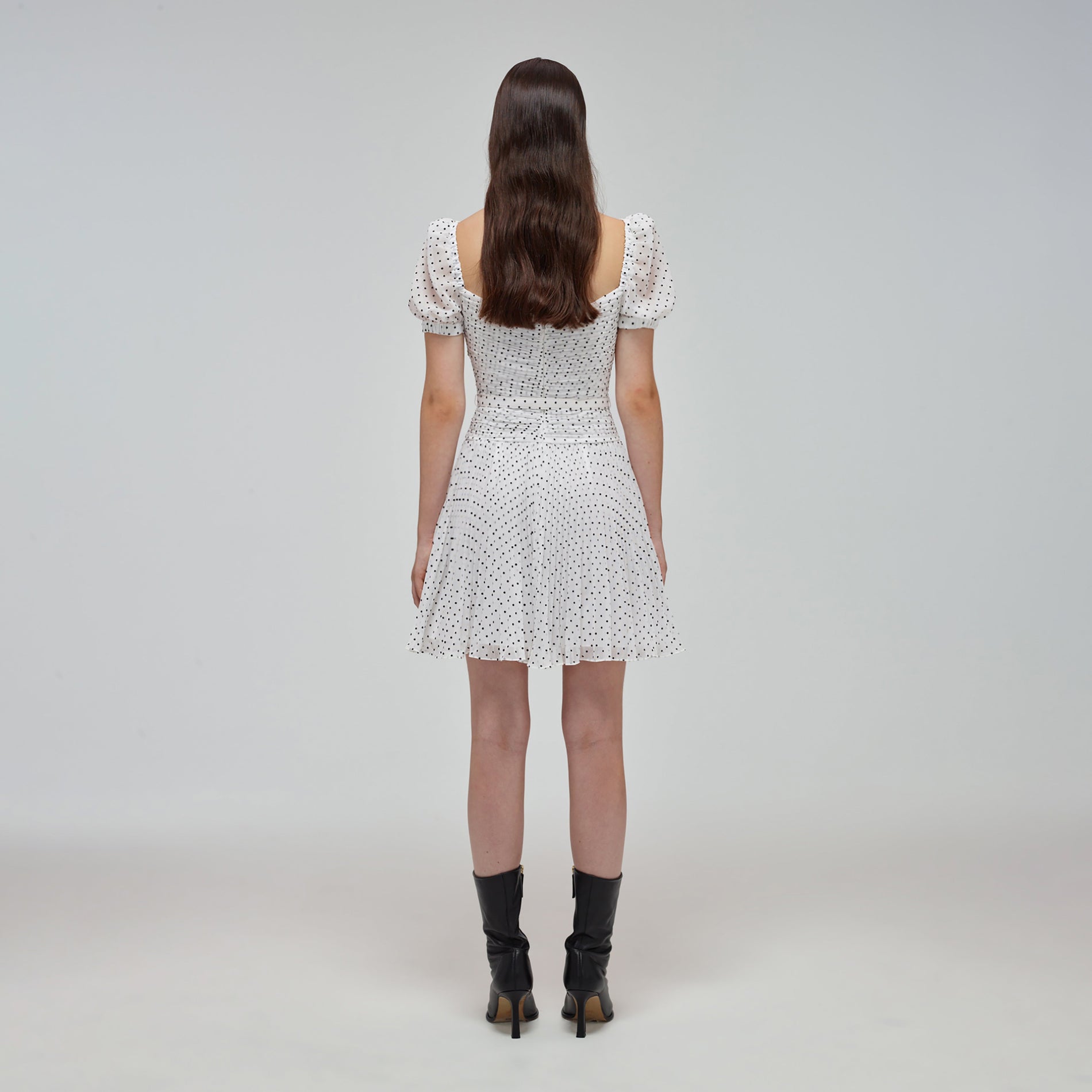 A woman wearing the White Crinkle Chiffon Dot Mini Dress