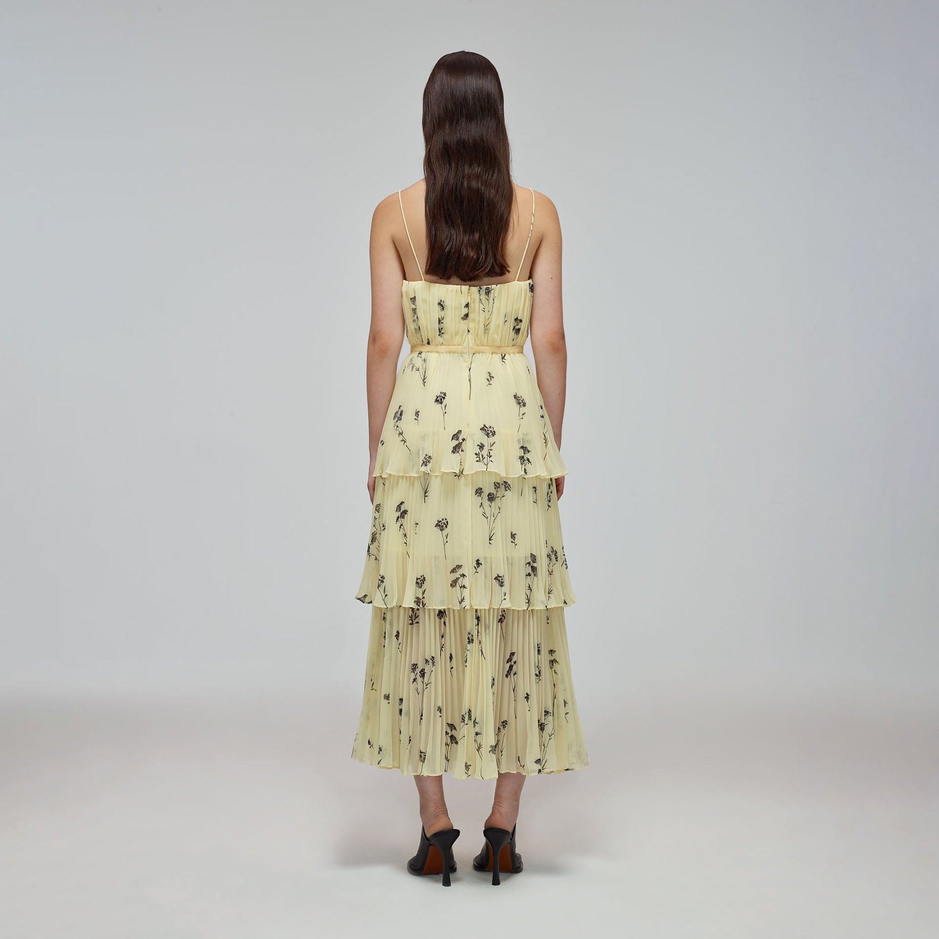 A woman wearing the Yellow Floral Silhouette Chiffon Tiered Midi Dress