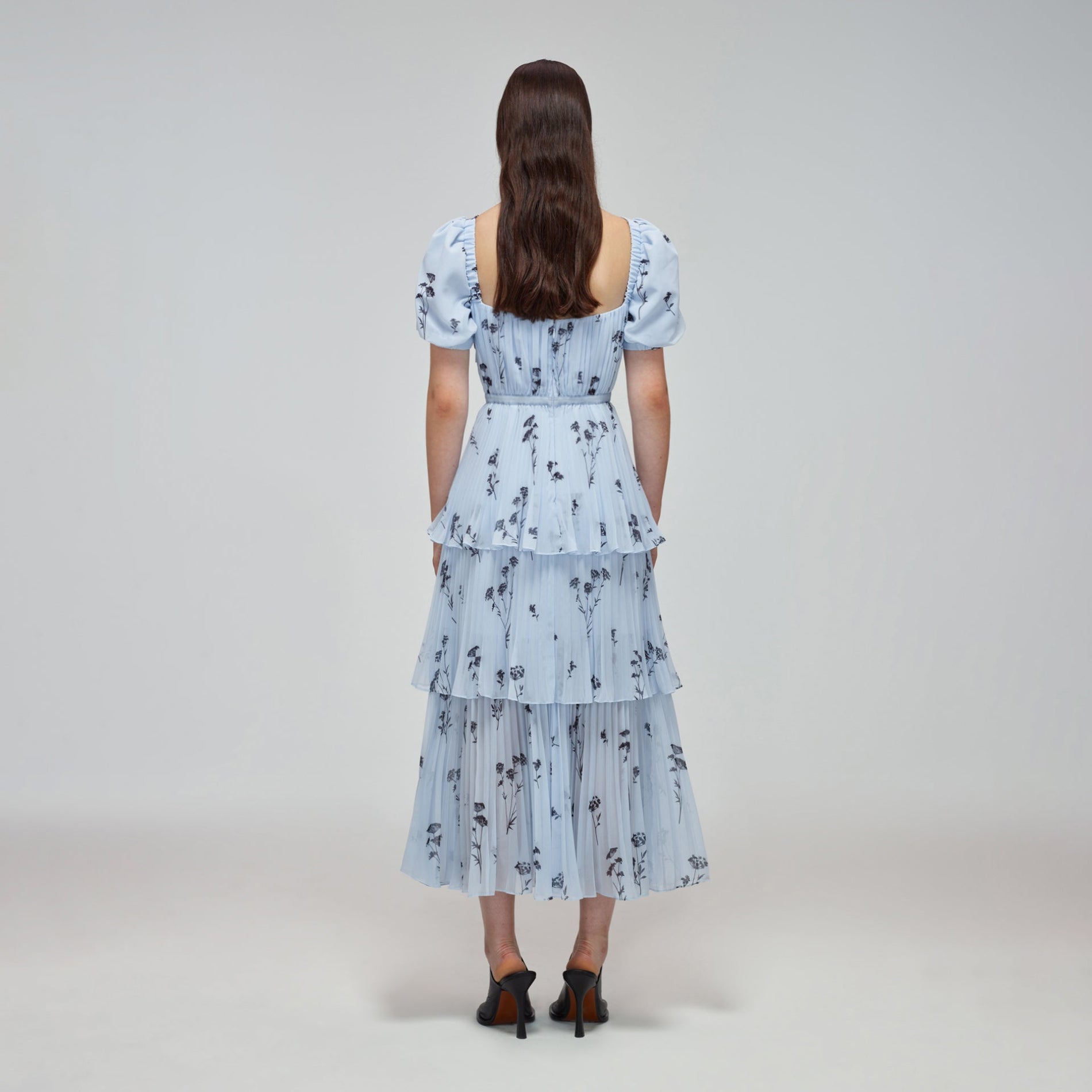 A woman wearing the Blue Floral Silhouette Chiffon Tiered Midi Dress