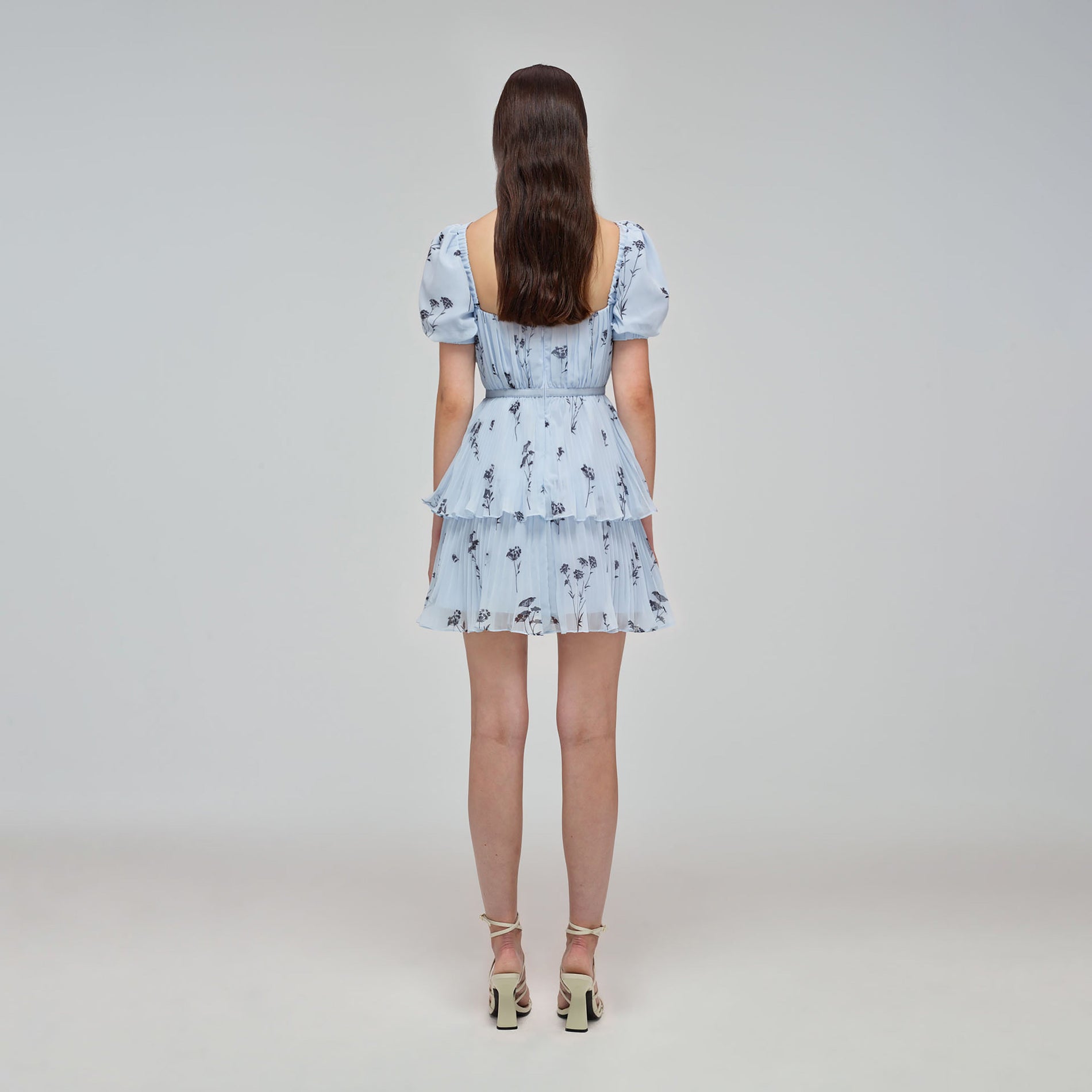 A woman wearing the Blue Floral Silhouette Chiffon Tiered Mini Dress