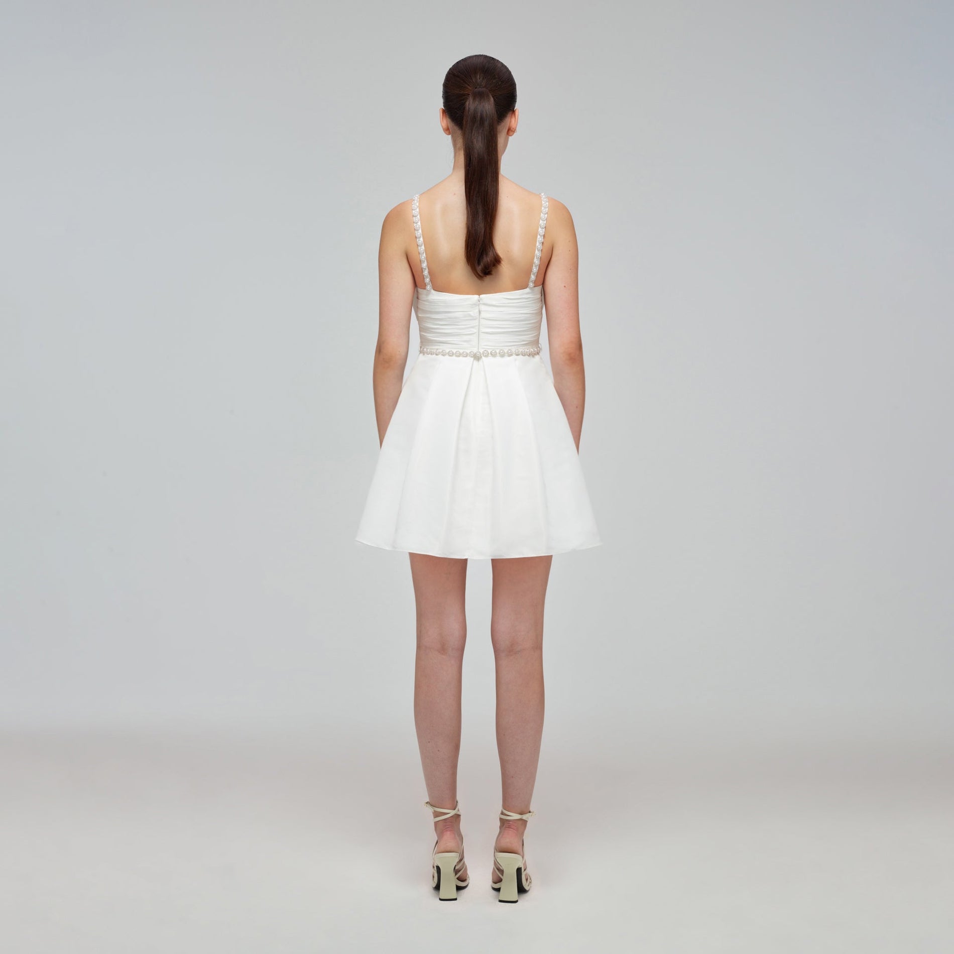 A woman wearing the White Taffeta Bow Mini Dress