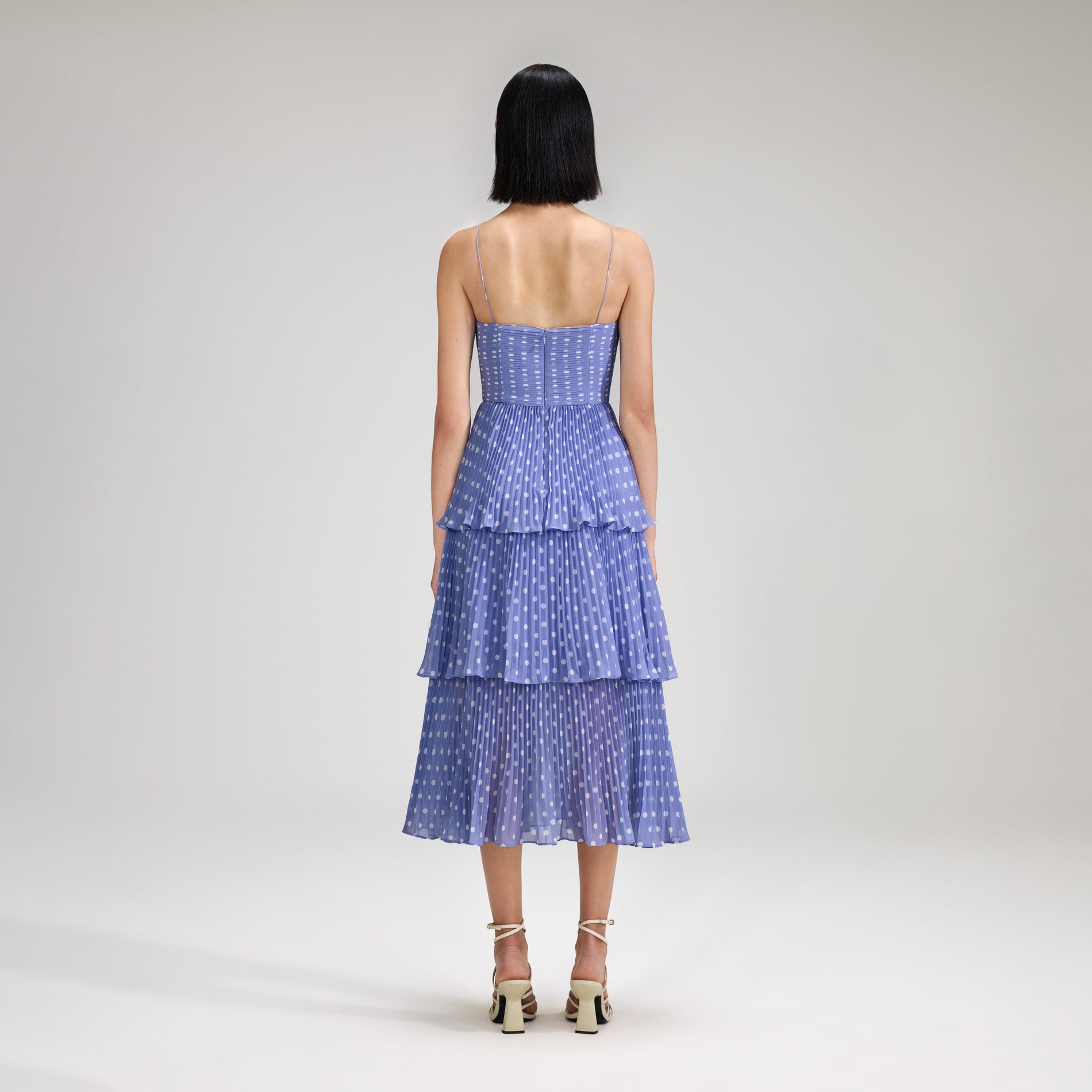 A woman wearing the Lilac Polka Dot Tiered Chiffon Midi Dress