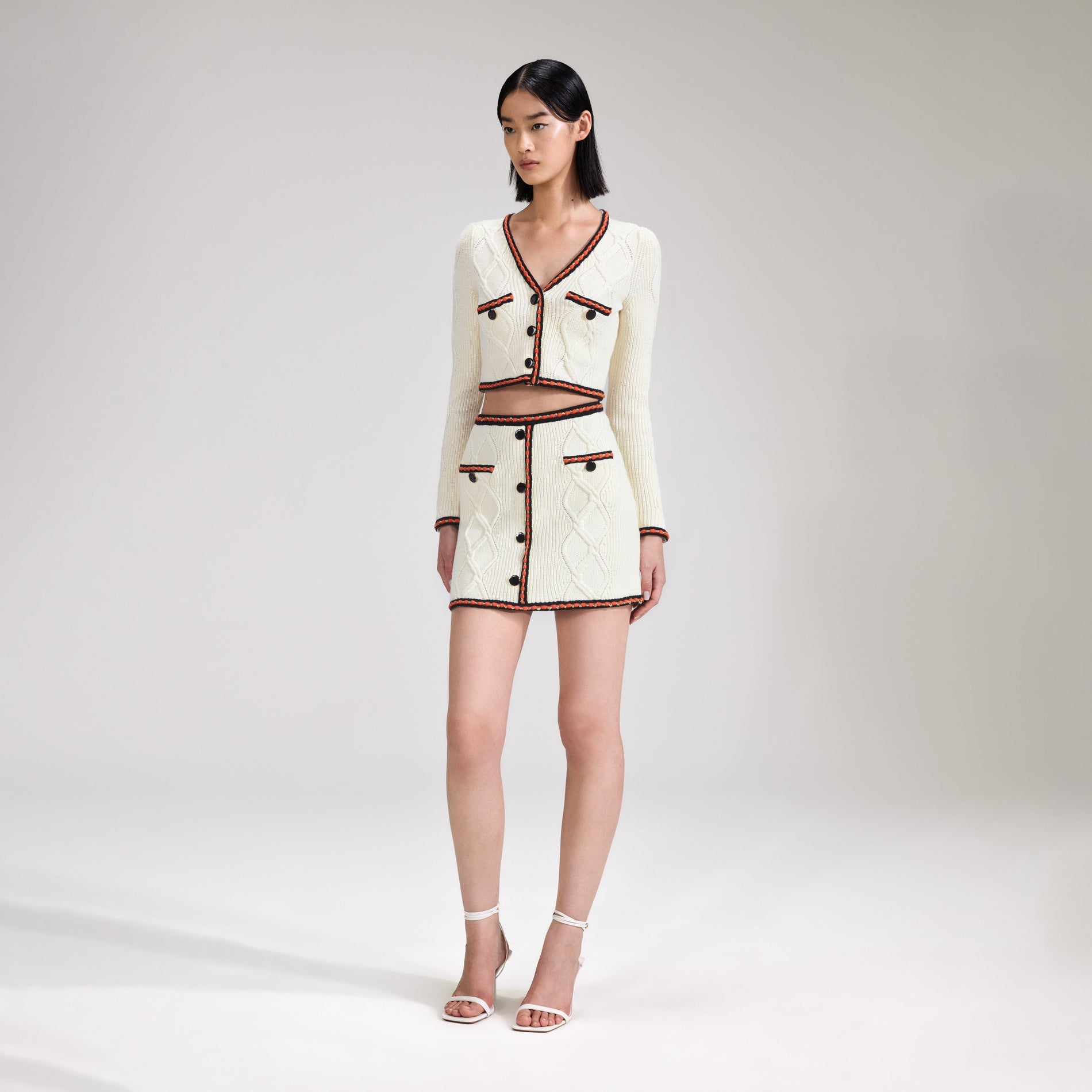 A woman wearing the Cream Cable Knit Skirt