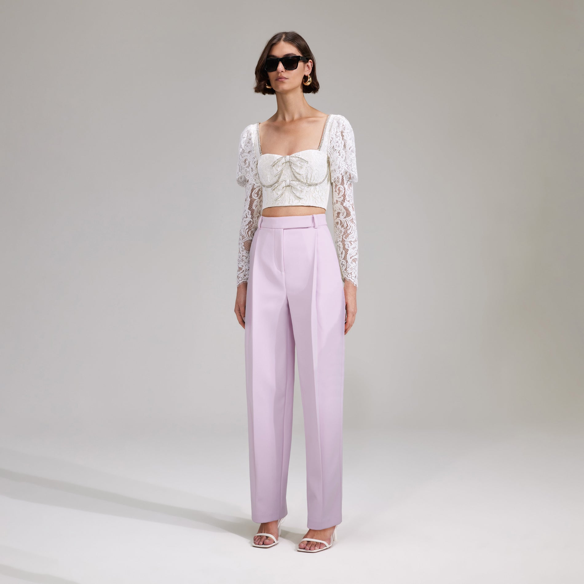 A woman wearing the Cream Cord Lace Cropped Top
