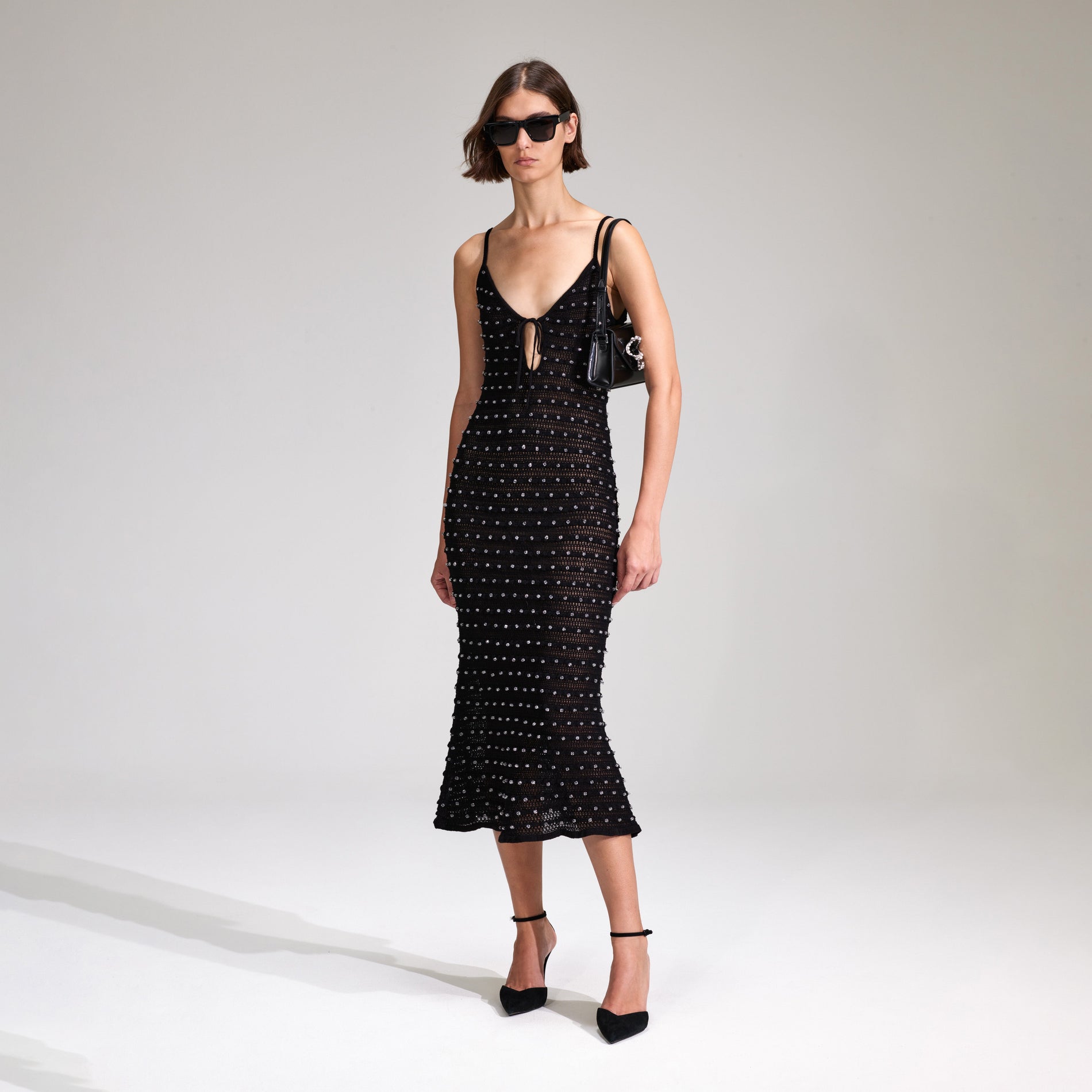 A woman wearing the Black Beaded Strappy Knit Midi Dress